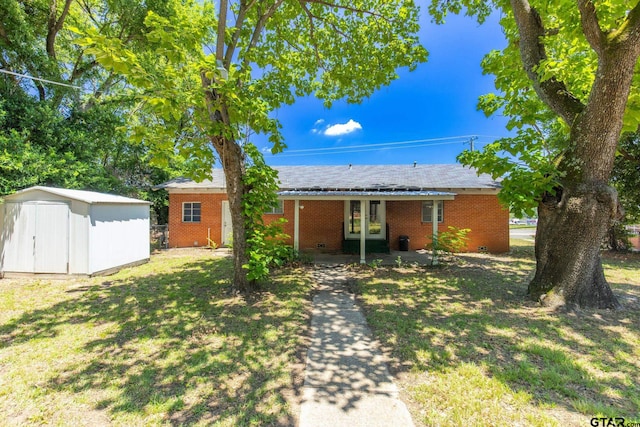 view of front of house featuring a storage unit, a front yard, and a patio