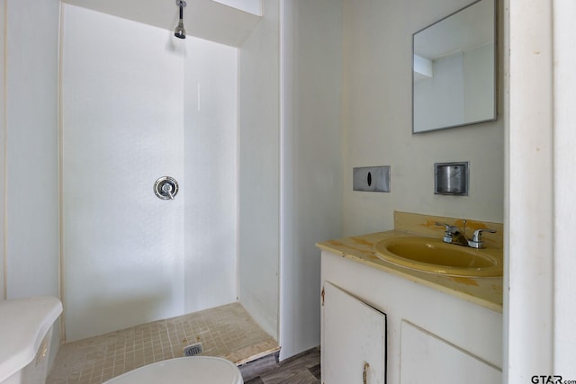 bathroom featuring a shower, vanity, toilet, and hardwood / wood-style floors