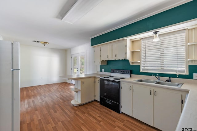 kitchen with black electric range, kitchen peninsula, sink, white fridge, and light hardwood / wood-style flooring