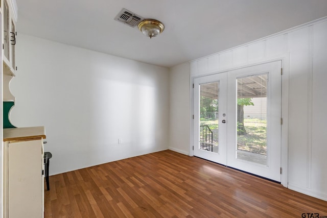 unfurnished living room featuring french doors and wood-type flooring