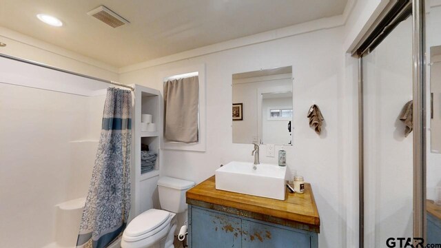 bathroom with vanity, curtained shower, and toilet