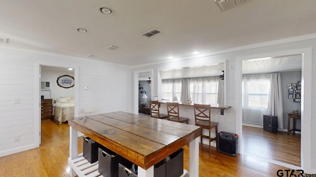 dining area featuring ornamental molding and light wood-type flooring