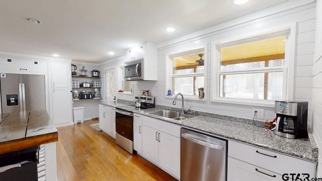 kitchen with sink, light hardwood / wood-style flooring, ceiling fan, white cabinetry, and stainless steel appliances