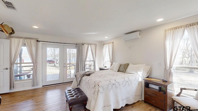 bedroom with light hardwood / wood-style flooring, access to outside, french doors, and a wall mounted AC