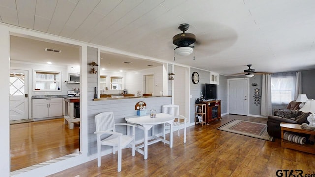 dining area featuring wood-type flooring and ceiling fan