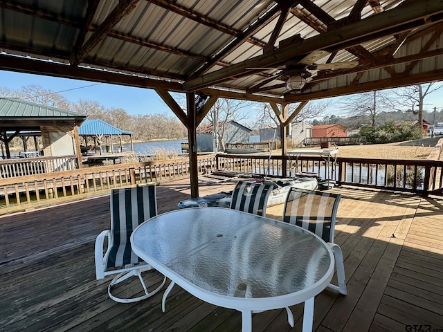 wooden terrace with a gazebo, ceiling fan, and a water view