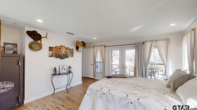 bedroom featuring access to exterior, light hardwood / wood-style floors, and french doors