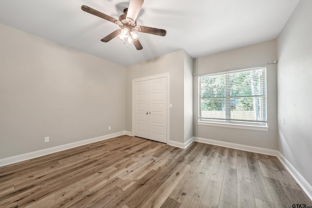 1534 Cimmarron Trl, Tyler, TX 75703 - unfurnished bedroom with wood finished floors, baseboards, and a ceiling fan