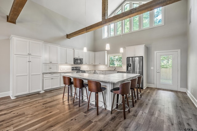 1534 Cimmarron Trl, Tyler, TX 75703 - kitchen featuring stainless steel appliances, high vaulted ceiling, a sink, a kitchen island, and white cabinets