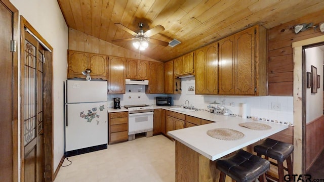 kitchen featuring white appliances, wood ceiling, sink, vaulted ceiling, and kitchen peninsula