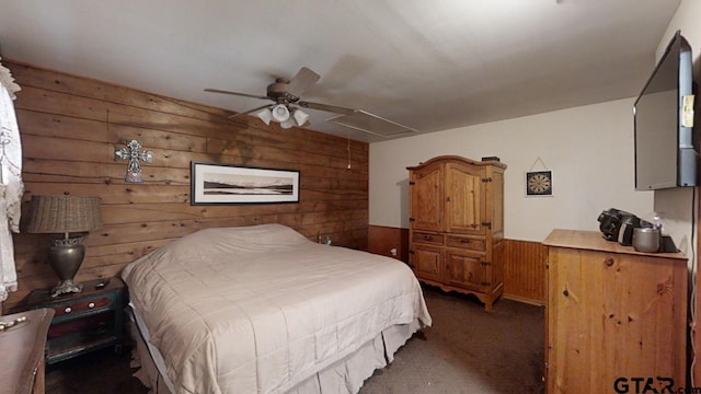 carpeted bedroom featuring ceiling fan and wooden walls