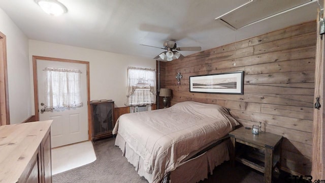 bedroom with wooden walls, dark colored carpet, and ceiling fan