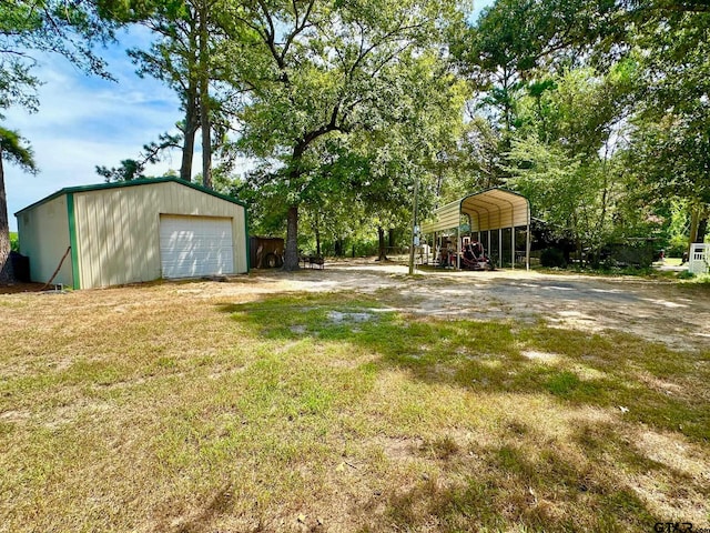 view of yard with an outbuilding, a garage, and a carport