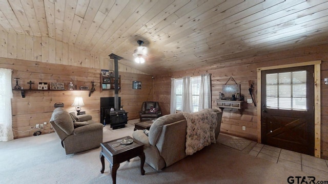 carpeted living room with a wood stove, wood ceiling, wooden walls, and vaulted ceiling