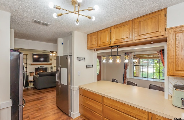 kitchen featuring an inviting chandelier, stainless steel fridge with ice dispenser, hanging light fixtures, stainless steel refrigerator, and light hardwood / wood-style floors