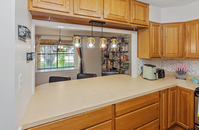 kitchen with tasteful backsplash, hanging light fixtures, and a textured ceiling