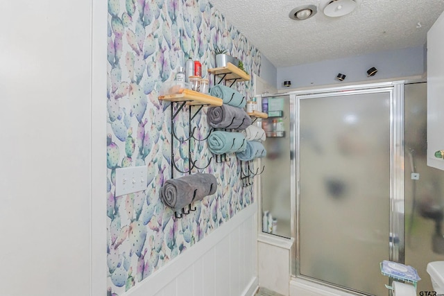 bathroom featuring an enclosed shower and a textured ceiling