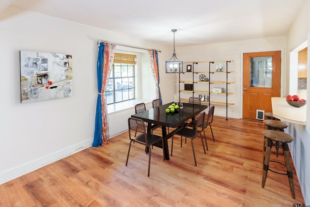 dining space featuring hardwood / wood-style floors and a chandelier