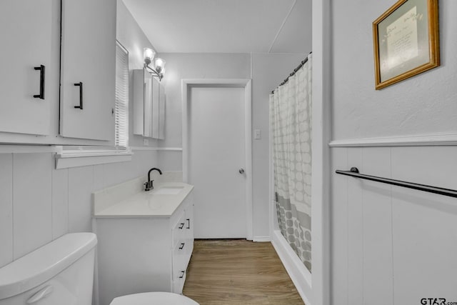 bathroom featuring a shower with shower curtain, vanity, hardwood / wood-style flooring, and toilet