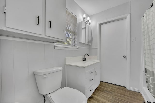 bathroom featuring a shower with shower curtain, vanity, hardwood / wood-style flooring, and toilet