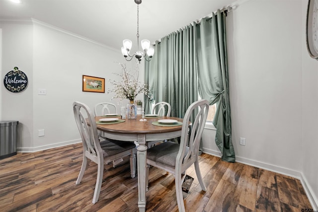 dining space with ornamental molding, a notable chandelier, and hardwood / wood-style flooring