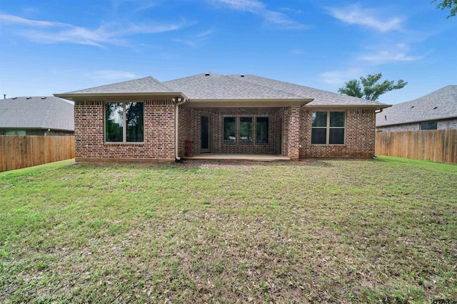 back of property featuring a lawn and a patio area