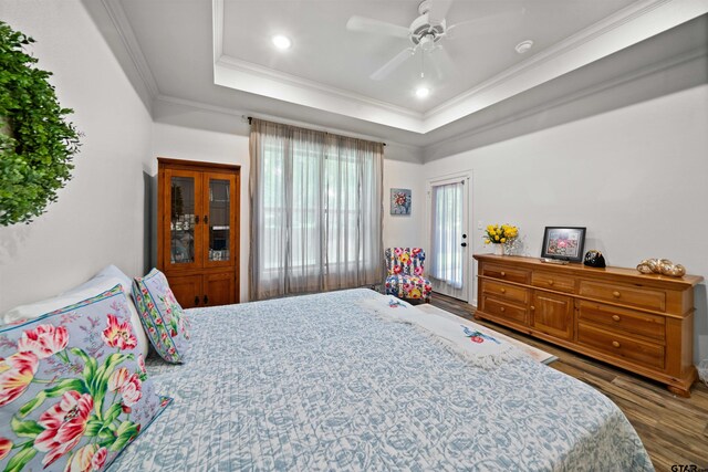 bedroom featuring ornamental molding, a tray ceiling, ceiling fan, and dark hardwood / wood-style floors