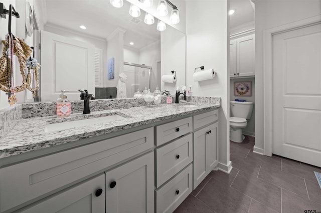 bathroom with tile patterned floors, toilet, a shower with door, ornamental molding, and vanity