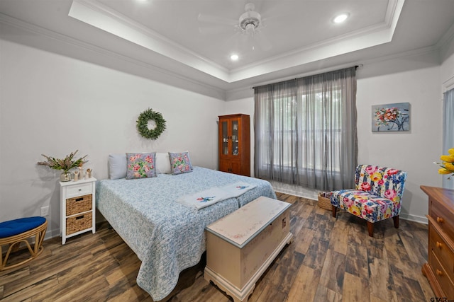 bedroom featuring ornamental molding, dark hardwood / wood-style floors, ceiling fan, and a tray ceiling