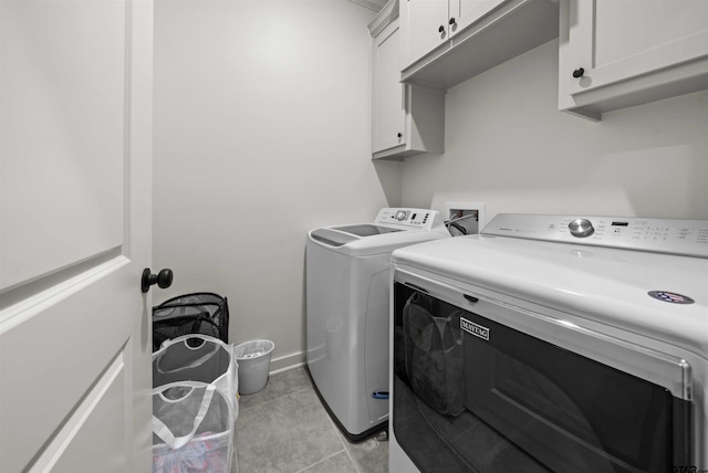 laundry area featuring cabinets, independent washer and dryer, and light tile patterned floors