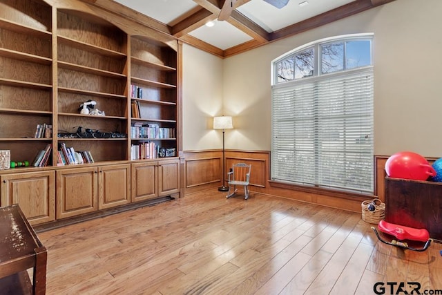 living area featuring light wood-style floors, beam ceiling, wainscoting, and coffered ceiling