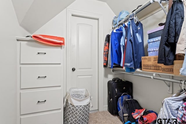 walk in closet featuring lofted ceiling and carpet floors