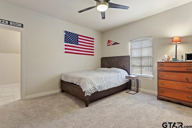 bedroom featuring a ceiling fan, light colored carpet, and baseboards