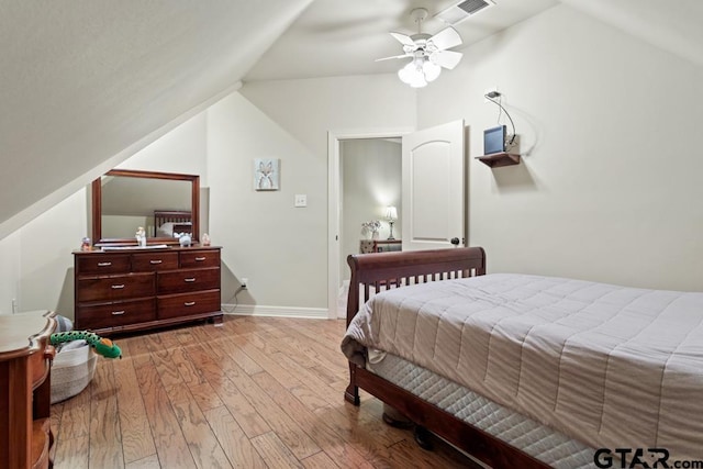 bedroom featuring light wood finished floors, lofted ceiling, visible vents, ceiling fan, and baseboards