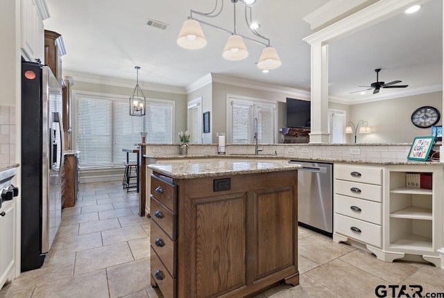 kitchen with pendant lighting, appliances with stainless steel finishes, a center island, and white cabinets