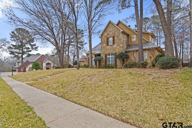 view of front facade with a front yard and stone siding