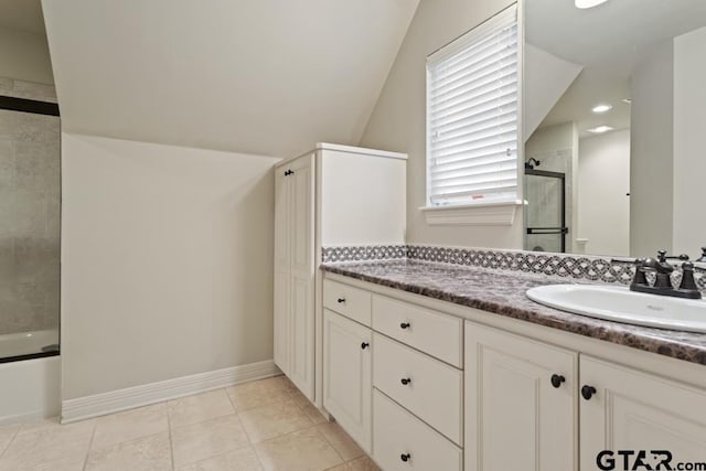 bathroom featuring lofted ceiling, tile patterned floors, baseboards, and vanity