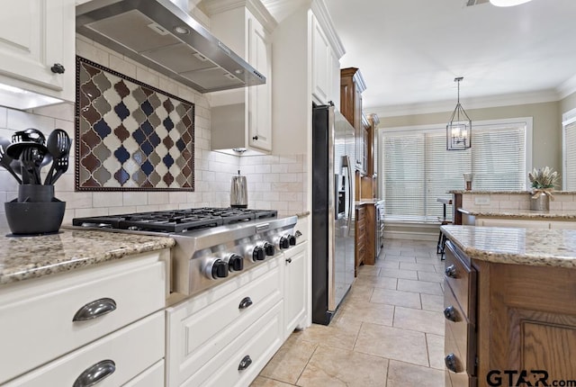 kitchen featuring appliances with stainless steel finishes, white cabinets, ornamental molding, and wall chimney exhaust hood