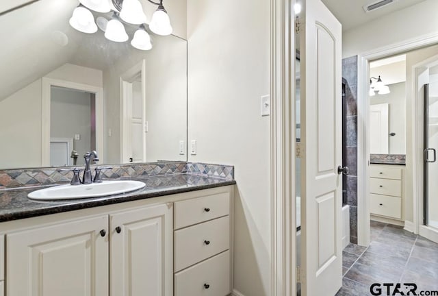 full bathroom with vaulted ceiling, visible vents, a shower with door, and vanity