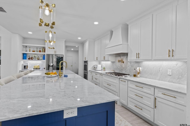 2680 Primera Rd, Tyler, TX 75705 - kitchen with stainless steel appliances, custom exhaust hood, a sink, white cabinets, and recessed lighting