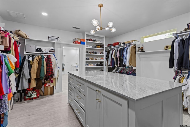 2680 Primera Rd, Tyler, TX 75705 - walk in closet featuring light wood finished floors and a chandelier