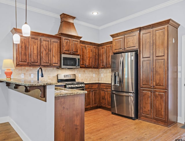 kitchen featuring kitchen peninsula, appliances with stainless steel finishes, light stone countertops, a breakfast bar area, and light wood-type flooring