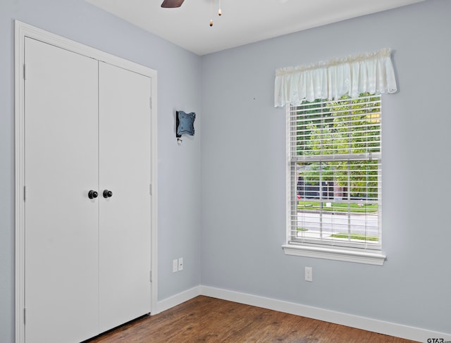 unfurnished bedroom featuring hardwood / wood-style flooring, ceiling fan, and a closet