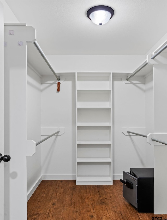 walk in closet with dark wood-type flooring