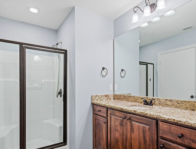 bathroom with vanity and a shower with shower door