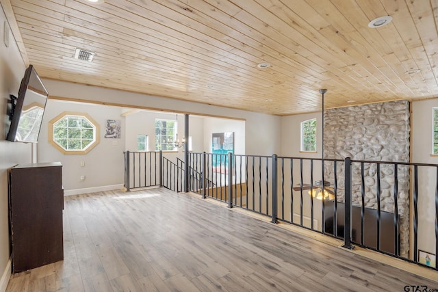 interior space featuring a healthy amount of sunlight, wooden ceiling, and light hardwood / wood-style flooring