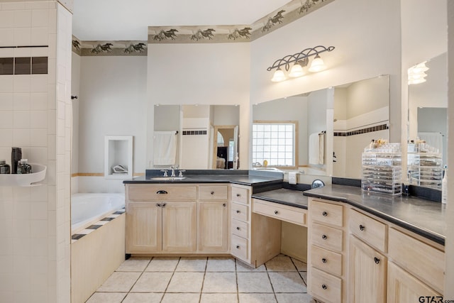 bathroom with vanity, tile patterned floors, and tiled tub