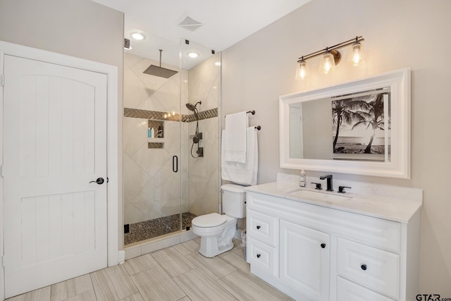 bathroom featuring vanity, toilet, and walk in shower