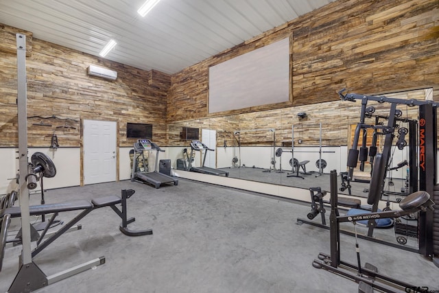 exercise room with a high ceiling and a wall mounted air conditioner