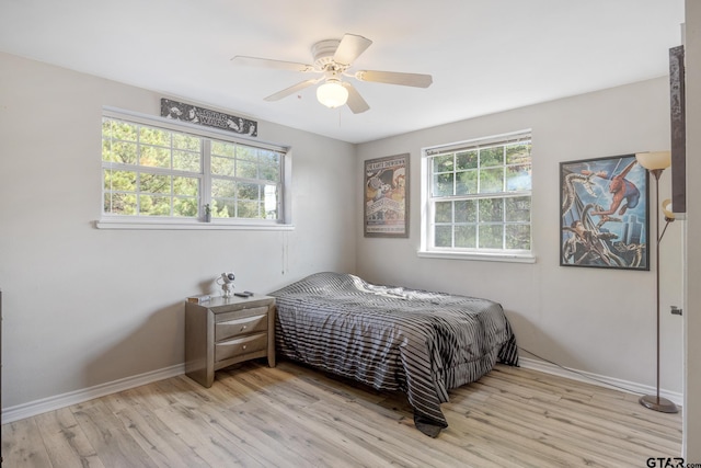 bedroom with light hardwood / wood-style flooring, multiple windows, and ceiling fan